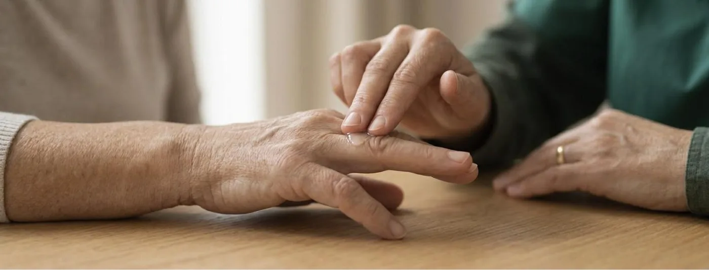 Narben an der Hand: Ein Finger verreibt einen Tropfen Creme in kreisenden Bewegungen auf dem Rücken eines anderen Fingers (Symbolbild, mit künstlicher Intelligenz erzeugt)